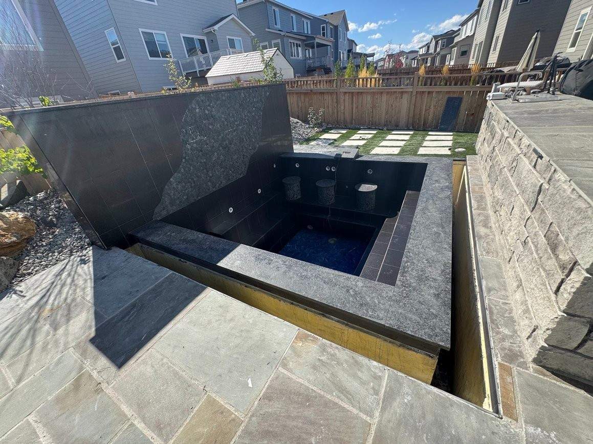 Outdoor tiled spa wall and stone pool surround built by Meza Tile & Stone